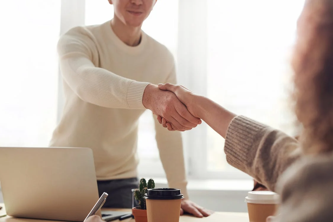 бизнес-партнеры жмут друг другу руку в знак сделки